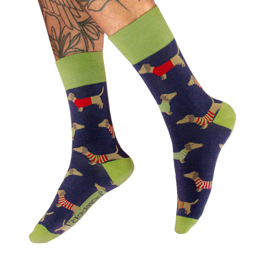 Blue socks with dachshund pattern and green accents worn by a person.