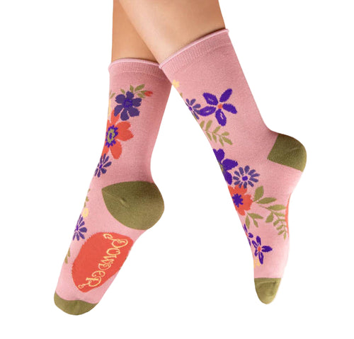 Pink socks with floral designs and green accents on a white background