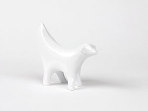 Ceramic white statue, shaped as the front half of a lamb combined with a banana.