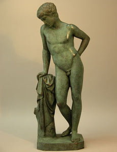 Bronze sculpture showing mythical figure Narcissus leaning on a short pillar and gazing at something.