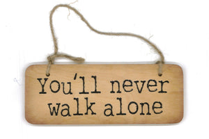 Wooden hanging sign with the phrase 'you'll never walk alone'